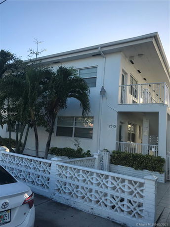 Front view of a two-story house with a decorative white fence.