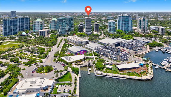 Aerial panoramic view of urban area with high-rise buildings, marina, and greenery.