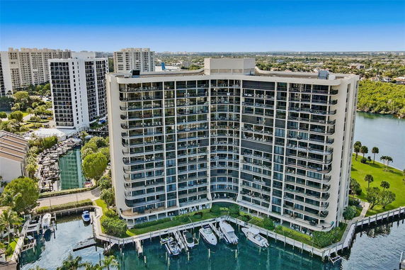 Front view of a multi-story building with balconies and waterfront access.