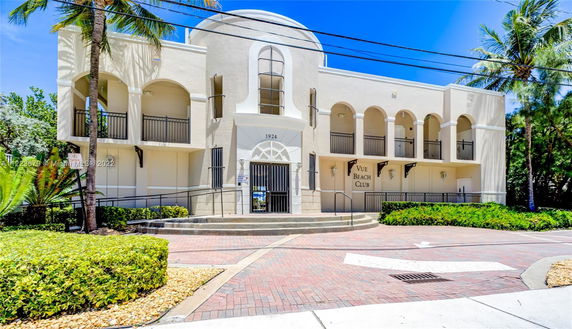Front view of a two-story building with arched balconies and a central entrance marked '1924' and 'Vue Beach Club'.