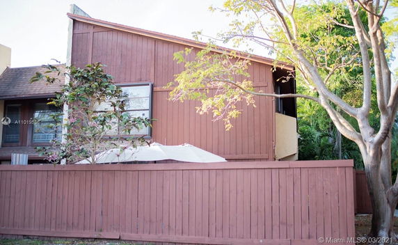 Front view of a two-story house with a brown wooden exterior.