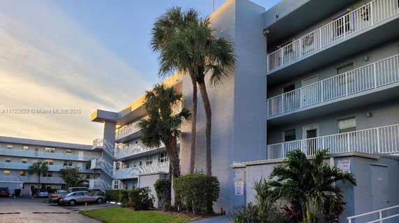 Front view of a multi-story building with balconies and exterior staircases.