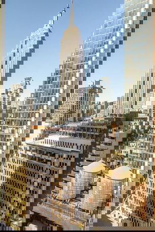 Panoramic view of a cityscape featuring several skyscrapers, including a prominent tall building in the center.