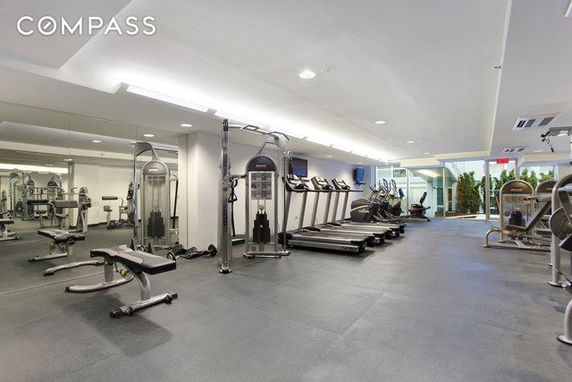 Indoor gym area with exercise equipment and mirrors.