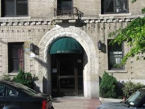 Front view of an apartment building with an arched entrance.