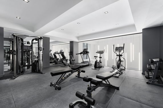 Interior view of a modern gym with exercise equipment such as treadmills and weights.