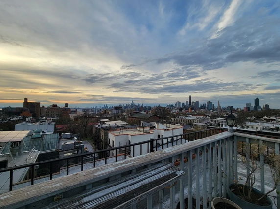 Panoramic view of a city skyline from a rooftop terrace.