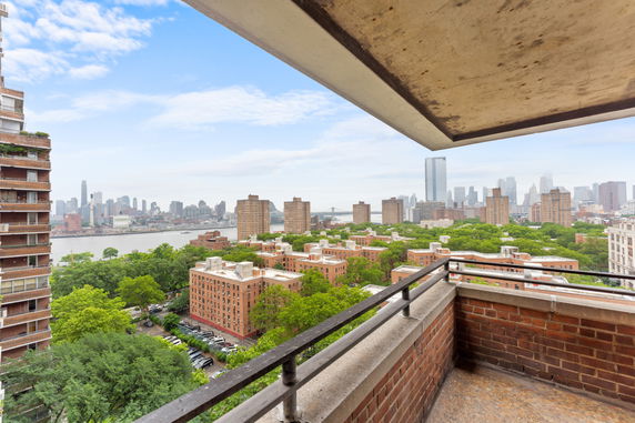 Panoramic view from a building showing a cityscape with high-rise buildings, river, and trees.