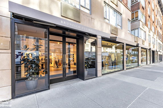 Street view of a clothing store with large windows on the ground floor of a building.