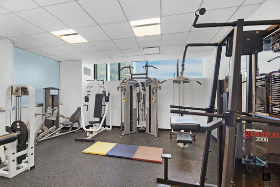 Interior view of a gym with various exercise equipment and mats.