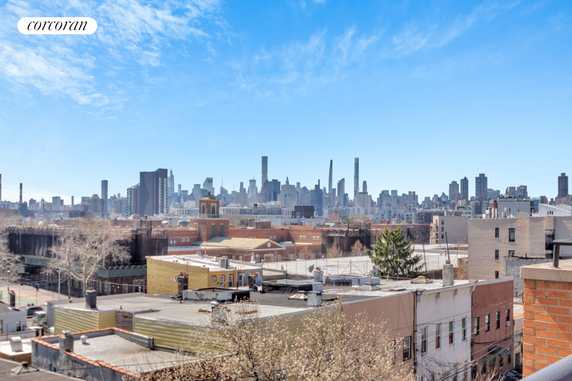 Panoramic view of city buildings and skyline under a clear blue sky.