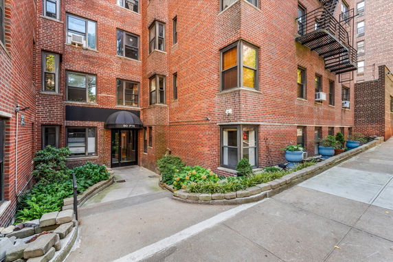 Front view of a brick apartment building with a canopy over the entrance.
