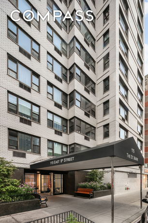 Front view of a multi-story apartment building with a covered entrance.