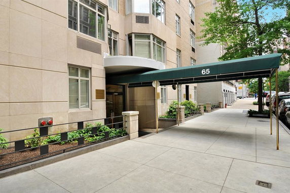 Front view of a building entrance with an awning labeled with the number 65.