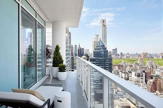 Panoramic view from a balcony overlooking city skyscrapers.