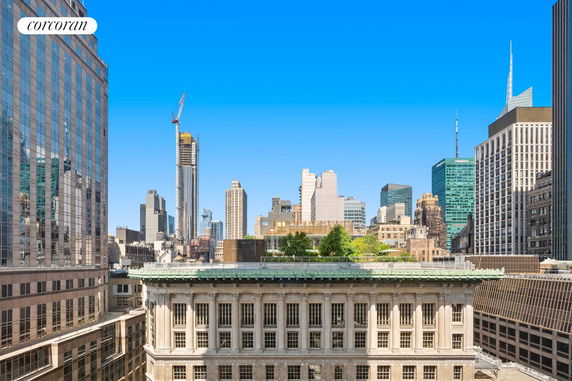 Panoramic view of a city skyline with multiple high-rise buildings under a clear blue sky.