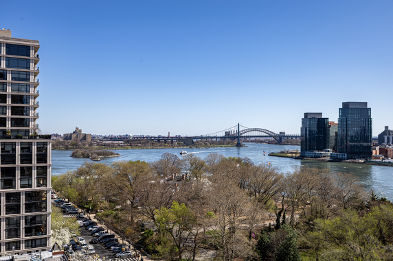 Panoramic view of a river with buildings and a bridge in the background.