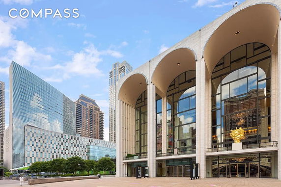 Front view of a large building with glass windows and tall arches.