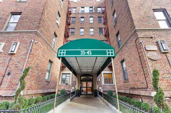 Front view of a brick residential building with an entrance awning.
