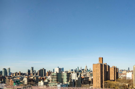 Panoramic view of city skyline with buildings under a clear blue sky.