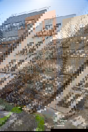 View of a multi-story brick building with fire escapes.