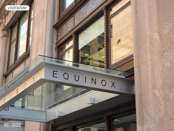 Front view of a commercial building with glass canopy and large windows.