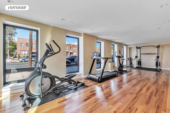 Room with gym equipment including exercise bikes and treadmill.