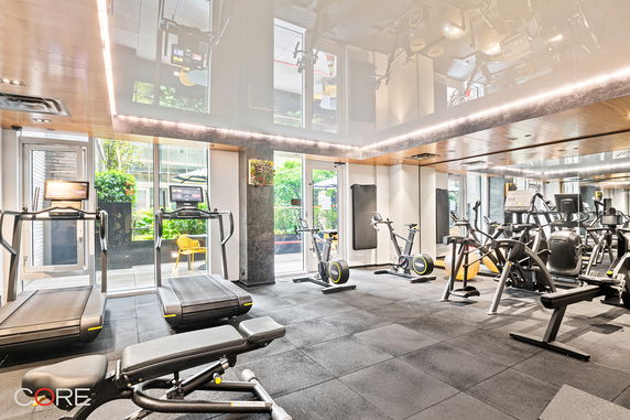 Interior view of a gym with exercise equipment, including treadmills and stationary bikes.