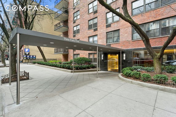 Front view of a multi-story apartment building with an entrance canopy labeled 'Three Forty Five'.