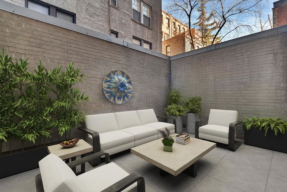 Rooftop seating area with outdoor furniture and wall decoration.