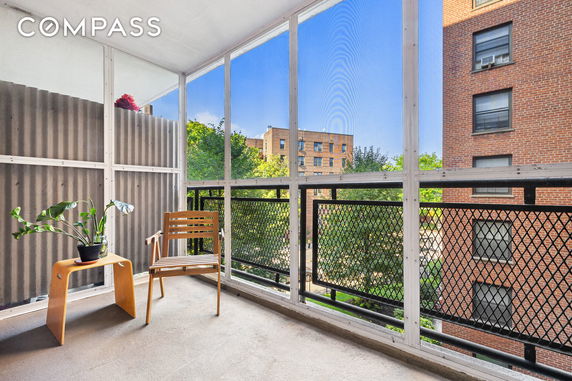 View from a balcony overlooking nearby apartment buildings and trees.
