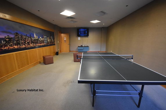 Indoor room with a table tennis setup and wall art.