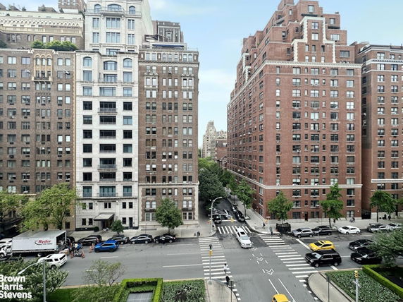 View of a city street with tall residential buildings on both sides.