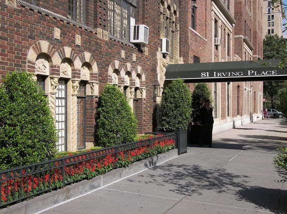 Front view of a building with decorative brickwork and arched windows.