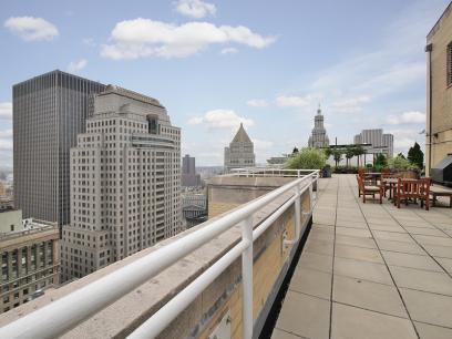 Rooftop view with seating area overlooking cityscape.