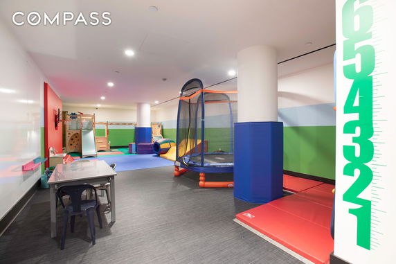 Indoor children's play area with play equipment and mats.