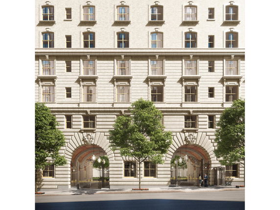 Front view of a multi-story building with decorative arch and windows.