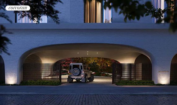 Exterior view of a building with an archway entrance leading to a parking area.