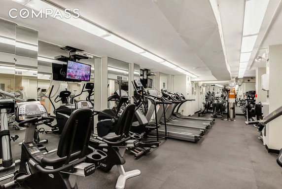 Well-equipped indoor gym with exercise machines and mirrored walls.
