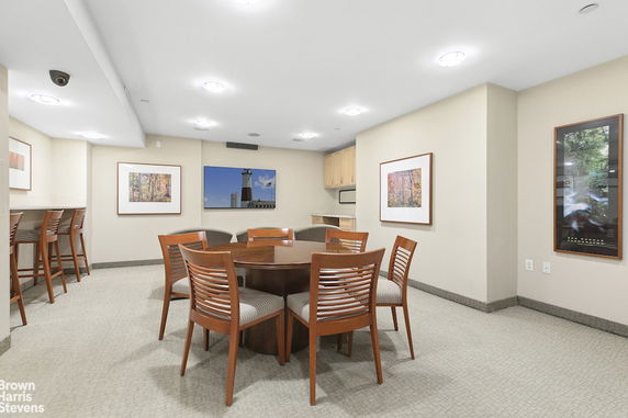 Recreational room with a round table, chairs, and wall art.