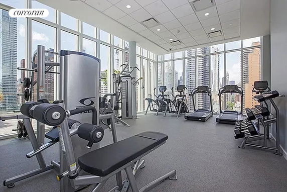 Gym area with exercise equipment and large windows.