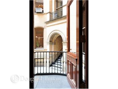 View from a balcony showing the surrounding building architecture with arches and railings.