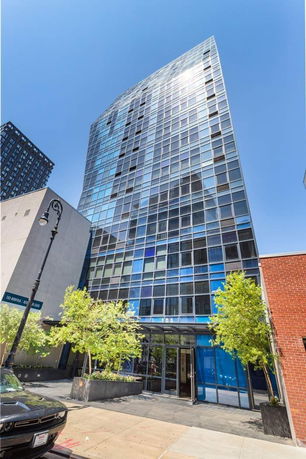 Front view of a modern high-rise building with a glass facade.
