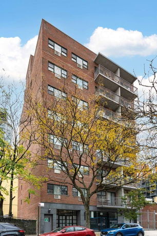 Front view of a multi-story brick building with balconies.
