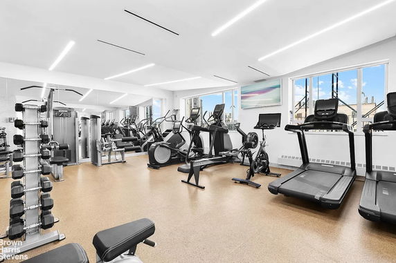 Indoor gym area with various exercise equipment, including treadmills, exercise bikes, and weight machines.