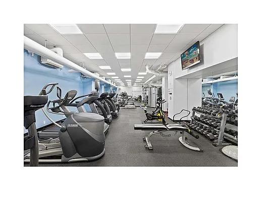 Indoor gym with exercise equipment and walls painted blue.