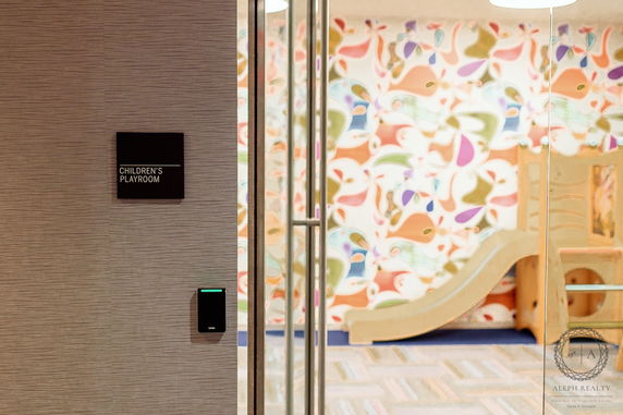 Entrance to a children's playroom with colorful wall patterns and a slide.
