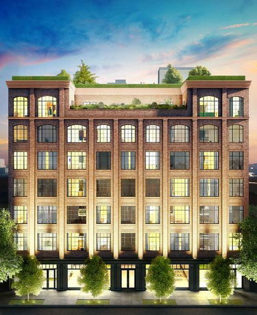 Front view of a multi-story residential building with large windows and rooftop greenery.