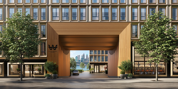 Front view of a modern multi-story building with large windows and a central archway leading to a view of a distant city skyline.