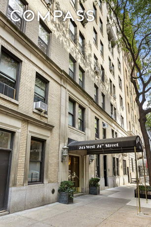 Front view of a multi-story apartment building with an entrance canopy.